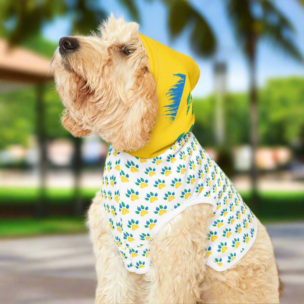 Dog wearing a yellow hoodie with paw print design on a white background