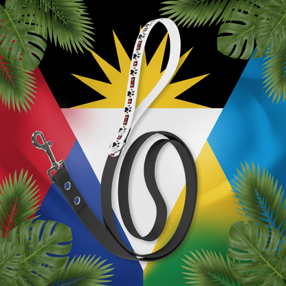 Black dog leash with a patterned handle on a sandy surface with shells and a starfish.